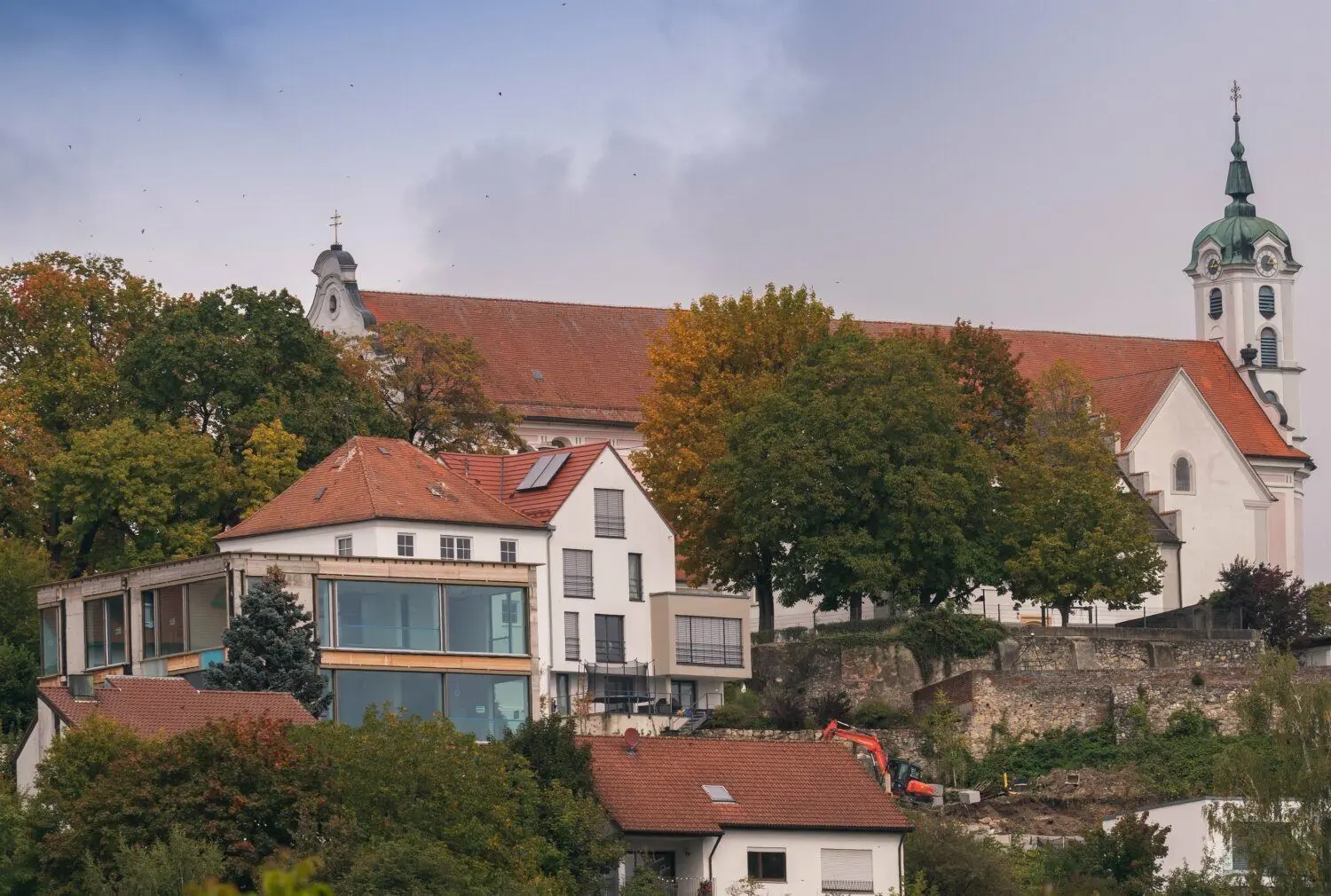 Die moderne Villa in Oberelchingen vor historischer Kulisse.