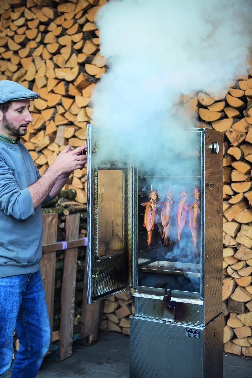 Buchautor Michael Wickert am Räucherschrank und vor einem idealen Hintergrund in Holzschwang.