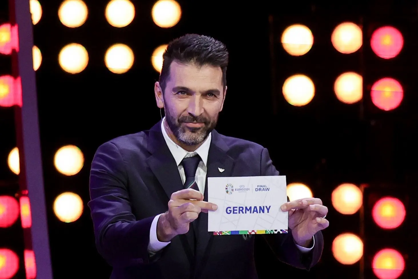 Gianluigi Buffon, ehemaliger Nationalspieler von Italien und Fußball-Weltmeister, hält den Zettel mit dem Team Deutschland in die Höhe.