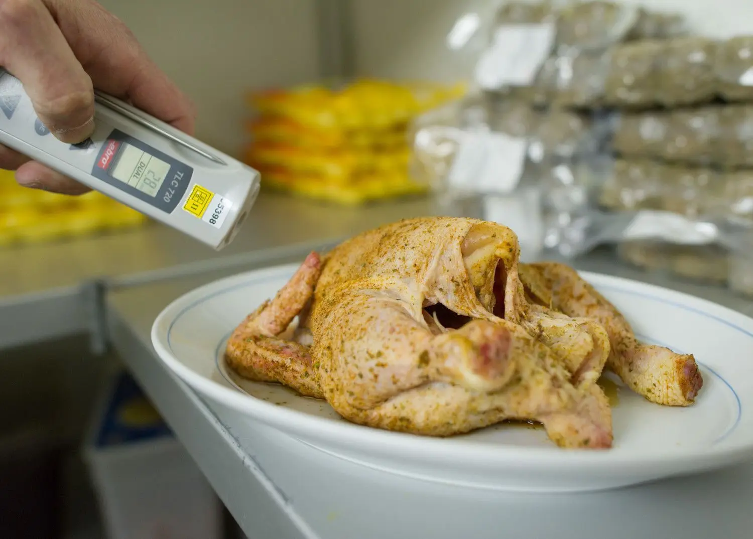 In Ordnung? Ein Prüfer kontrolliert die Temperatur eines Hähnchens. ⇥