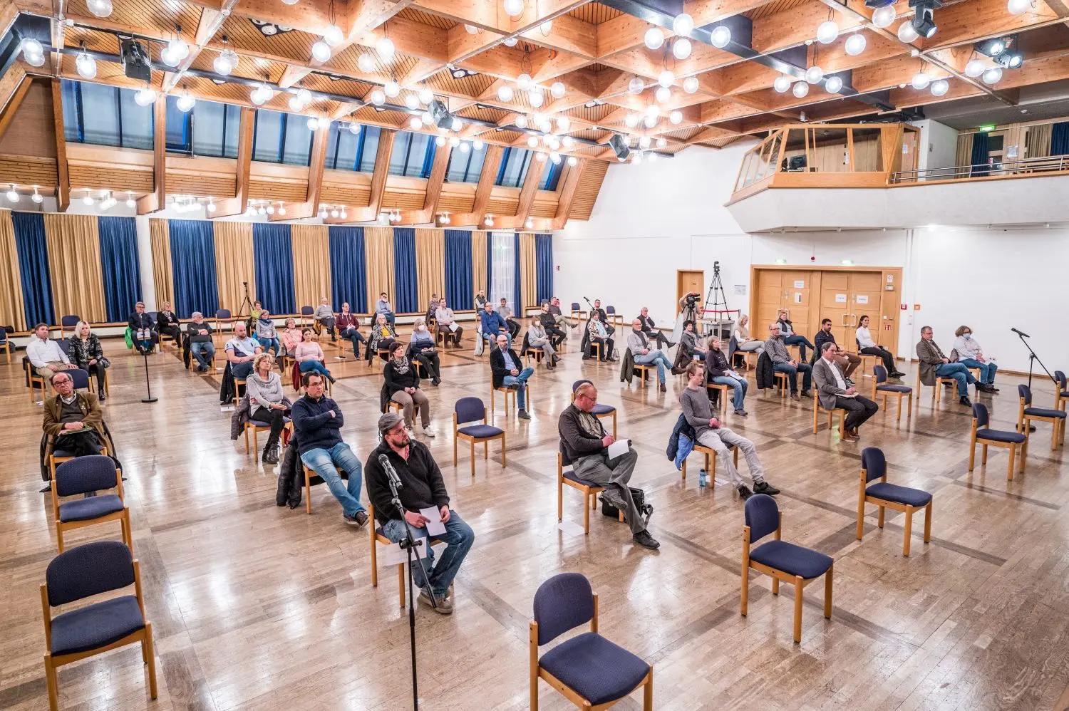 Etwa 50 Besucher erleben live die Veranstaltung in der Stadthalle, viele mehr sind online zugeschaltet. ⇥