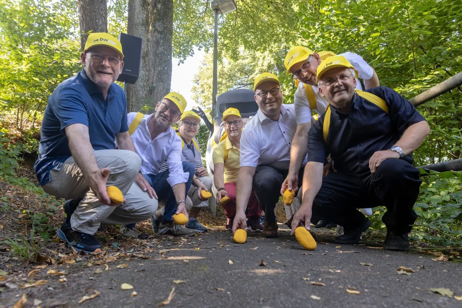 Auf dem neuen Wanderweg werden gelbe Steine abgelegt. Von links: Verkehrsminister Winfried Hermann, Bürgermeister Christoph Jäger (Großerlach), die erste stellvertretende Bürgermeisterin von Sulzbach an der Murr, Edelgard Löffler, die Bürgermeister Reinhold Sczuka (Althütte),  Armin Mößner (Murrhardt) und Ralf Glenk (Fichtenberg) sowie Waldmeister Walter Hieber. ⇥