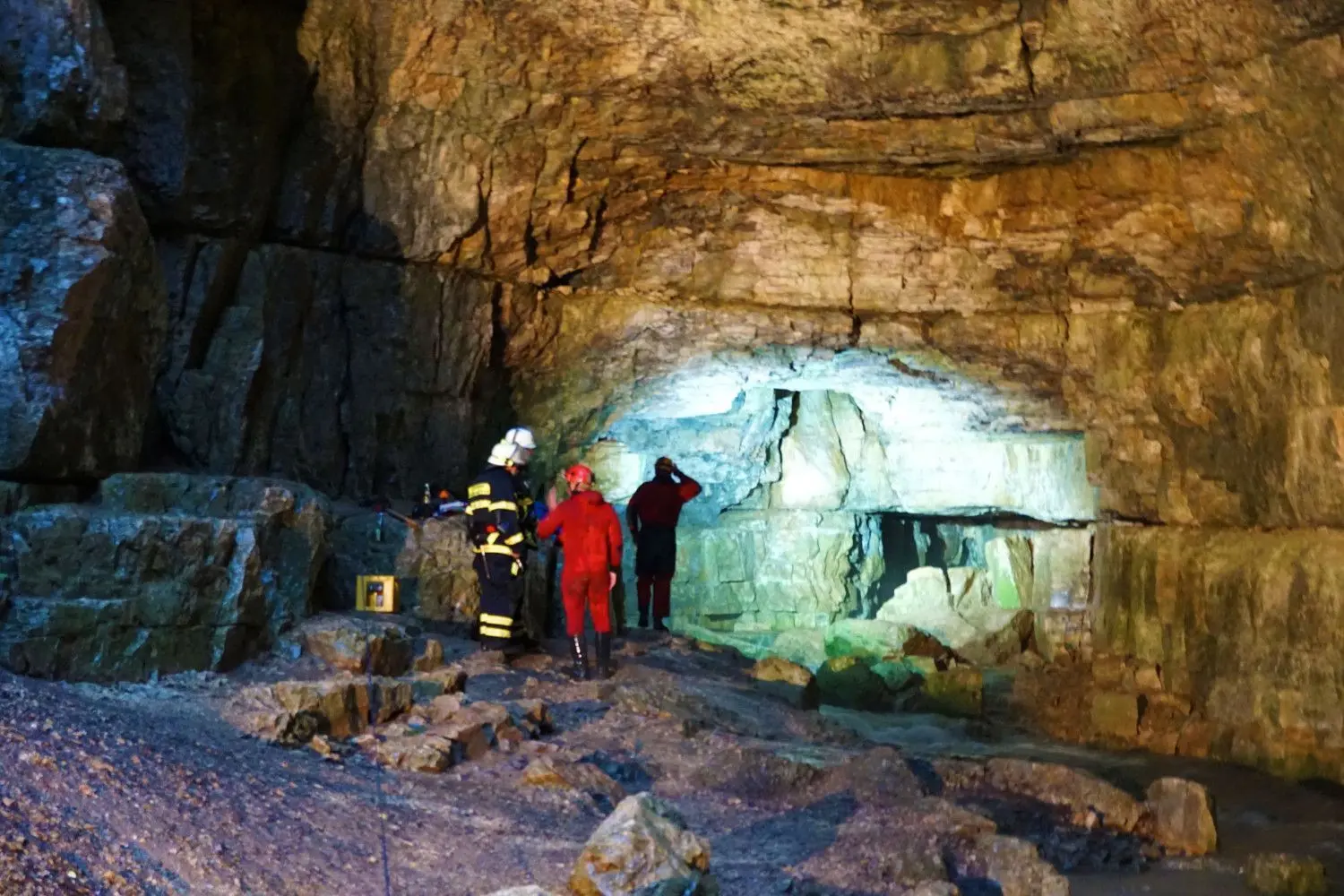 Einsatzkräfte der Bergwacht und Feuerwehrleute stehen am Eingang der Falkensteiner Höhle.