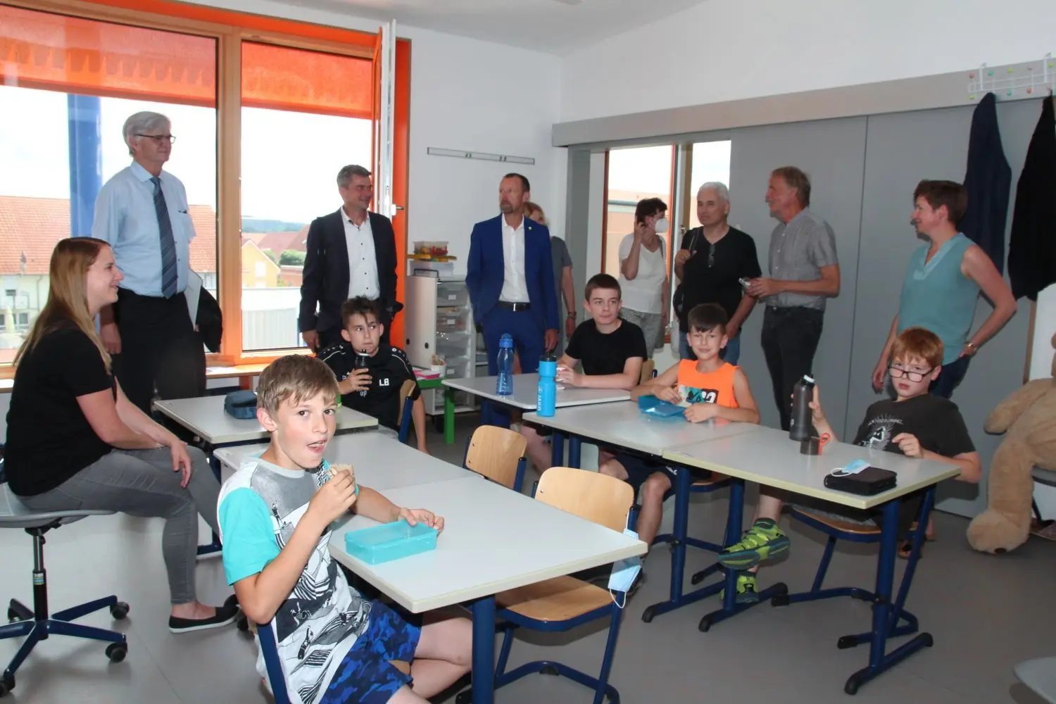Beim Rundgang durch den Schulhausneubau erklärt Thomas Buchholz, Geschäftsführer Reha-Südwest Ostwürttemberg-Hohenlohe (Zweiter von rechts), den Gästen der Eröffnungsfeier die Vorzüge der ganz auf Inklusion ausgerichteten Klassenzimmer. ⇥