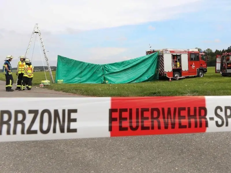 Feuerwehrleute haben auf dem Flugplatz einen Sichtschutz errichtet.