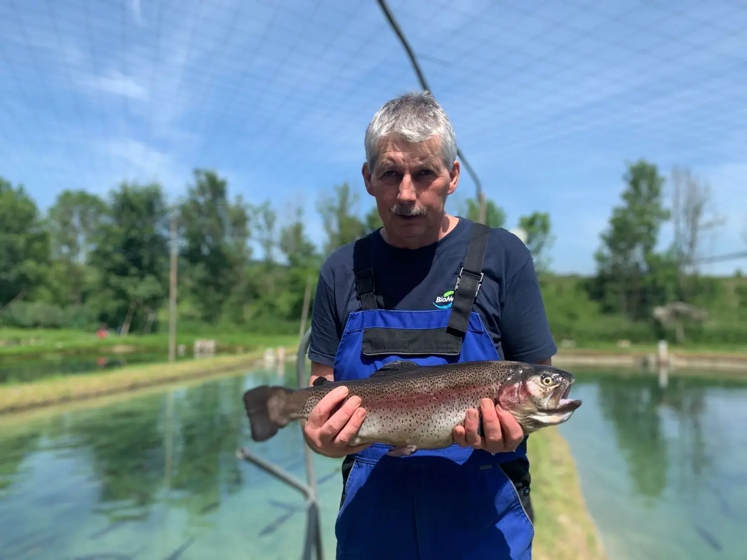 Matthias Scholz, der in Datthausen bei Obermarchtal den Fisch- und Angelpark betreibt, mit einer Regenbogenforelle.