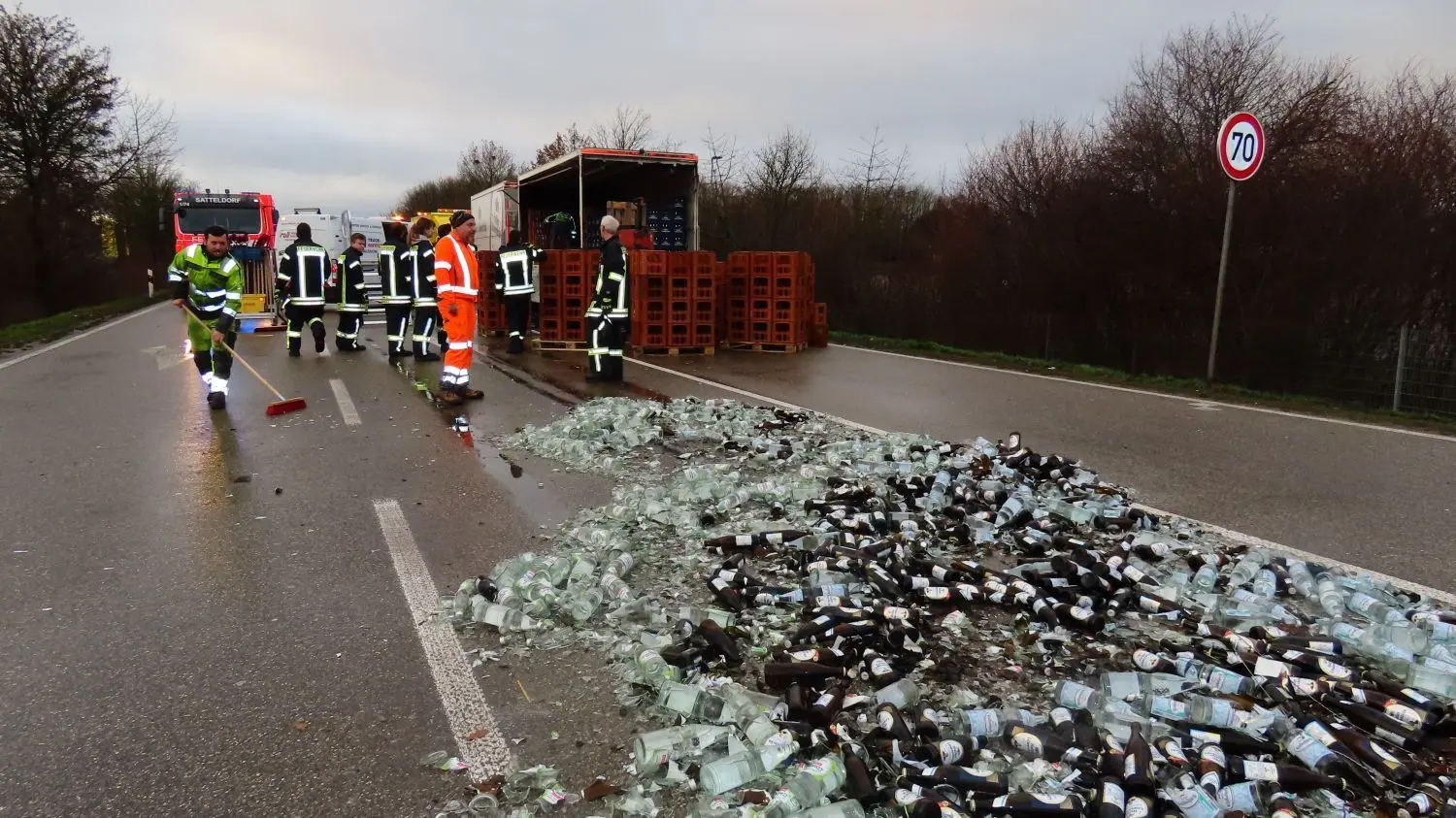 Getränkeflaschen im Wert von rund 10000 Euro liegen zertrümmert auf der Straße.