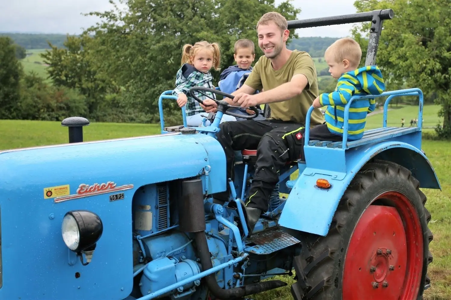 Ein Teilnehmer des Treffens fährt Kinder auf seinem Traktor über das Gelände in Bartenbach.⇥
