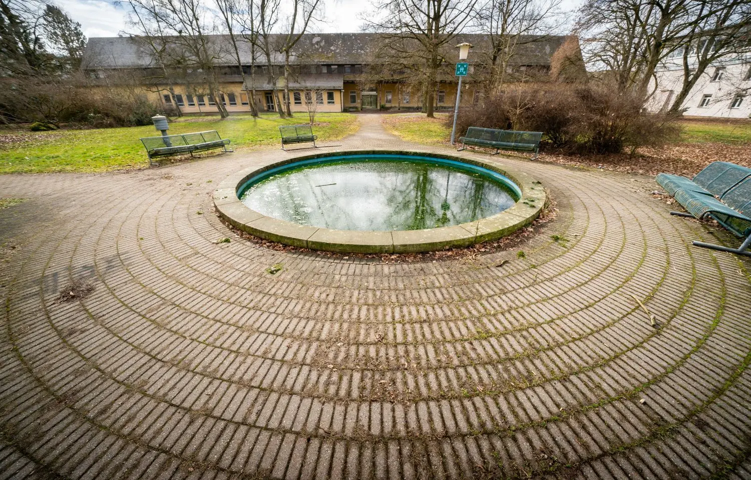 Hinter dem stillgelegten Springbrunnen liegt Haus 4: Dort ist ein Quartiertreff denkbar oder eine Kinderbetreuung.
