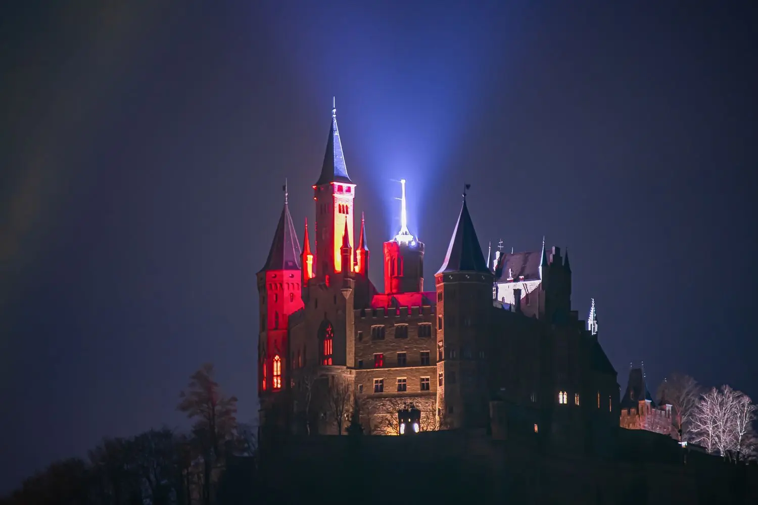 Die Burg farbig illuminiert, vom beleuchteten Fahnenturm werden Lichtstrahlen in den nächtlichen Himmel geschickt. Hartmut Pflumm aus Bisingen hielt diesen Anblick am Dienstagabend für uns fest.