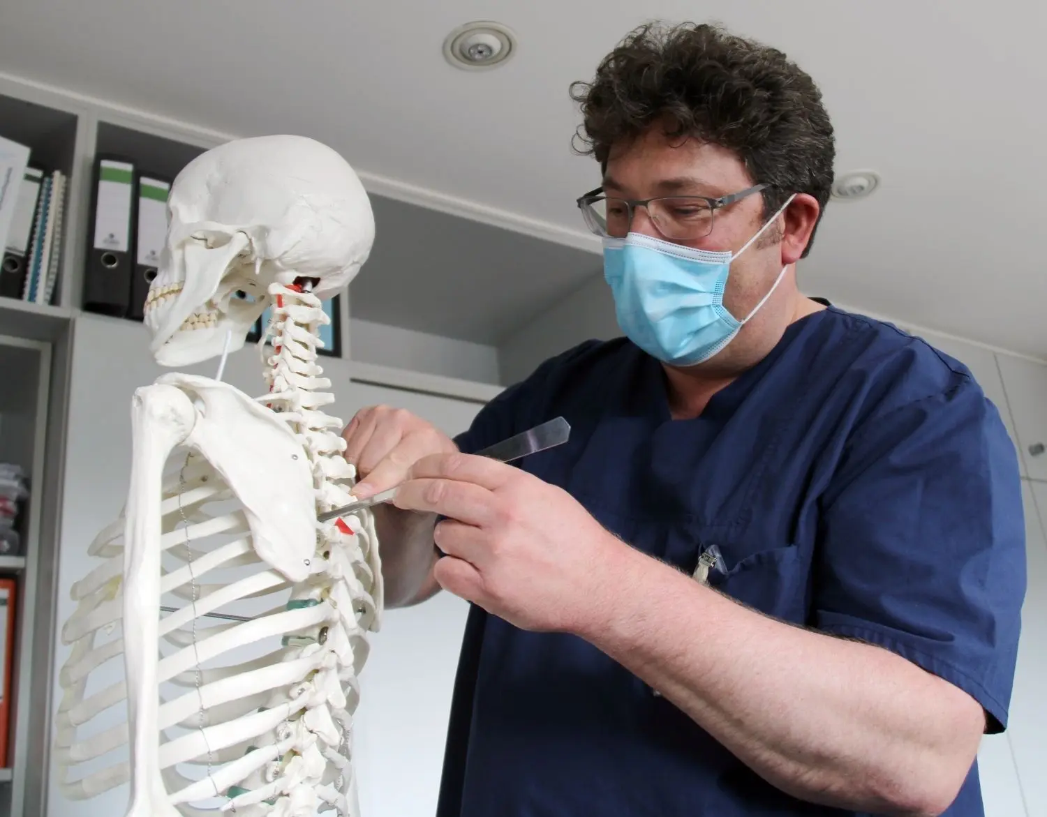 Dr. Stefan Huber-Wagner zeigt am Modell, wie die Ärzte den Zugang zum Wirbel schaffen.
