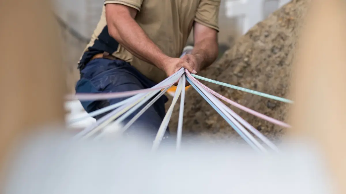 In Rüdersdorf verlegt DNS:Net auf eigene Kosten Glasfaser für schnelleres Internet. Ein Ortsteil bleibt bislang außen vor. (Symbolbild)
ARCHIV - Ein Mitarbeiter einer Erdbaufirma bündelt am 28.06.2017 in Warendorf-Müssingen (Nordrhein-Westfalen) Glasfaser-Leerrohre zusammen. In Kooperation mit der Stadt Warendorf baut die Unternehmensgruppe Deutsche Glasfaser in den vier Ortsteilen der Stadt Warendorf eine Glasfaserinfrastruktur mit Glasfaseranschlüssen für den Breitband-Internet-Ausbau auf. (zu "Internet und mehr - Was wollen die Parteien für ländliche Räume?" vom 19.09.2017) Foto: Guido Kirchner/dpa +++(c) dpa - Bildfunk+++