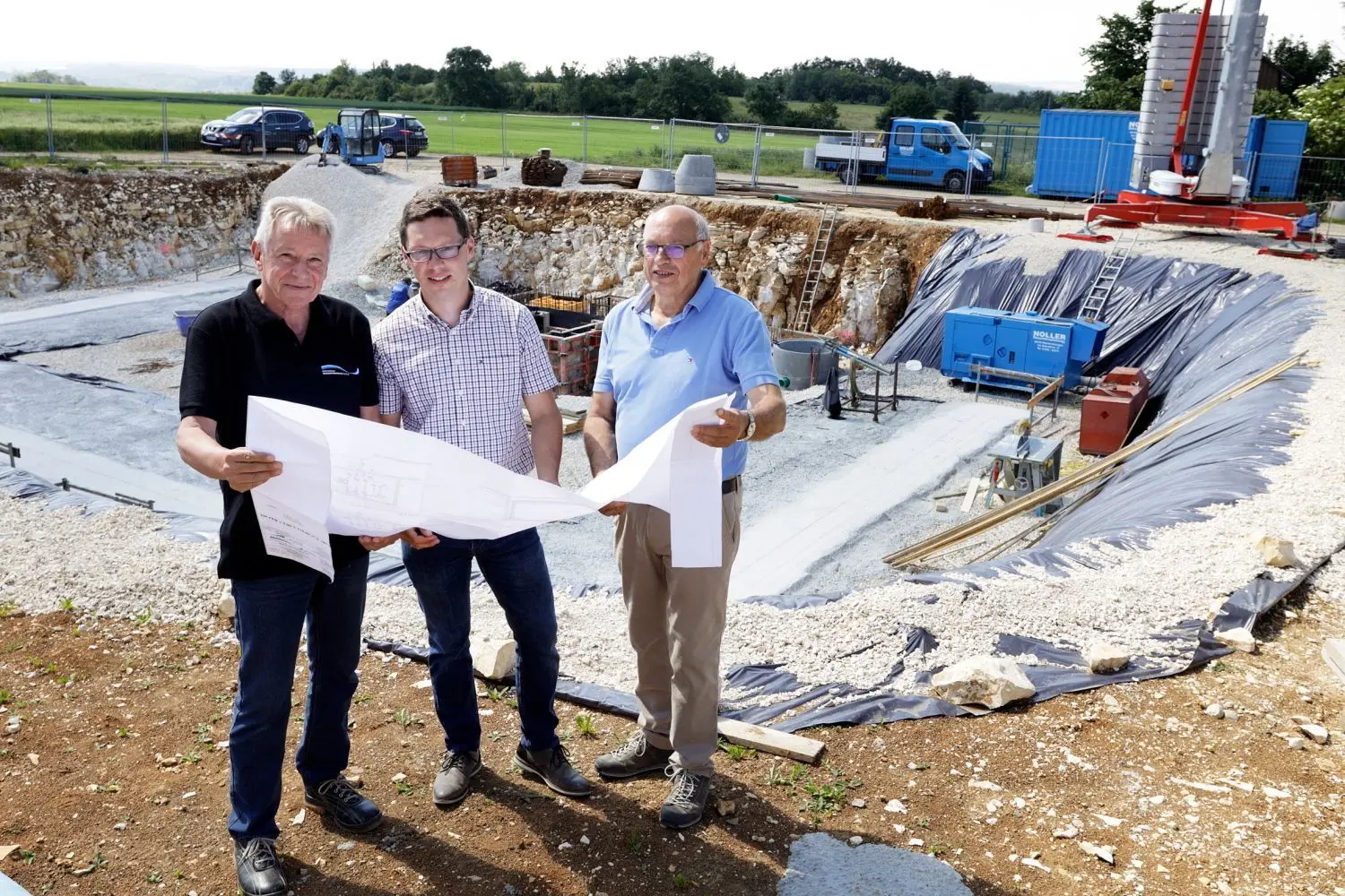 Der Technische Betriebsleiter des Zweckverbands Wasserversorgung Ostalb, Walter Banzhaf, Geschäftsführer Uwe Geiße und der Stöttener Ortsvorsteher Hermann Eberhardt (von links) vor der Baugrube des zukünftigen neuen Wasserhochbehälters in Stötten.⇥