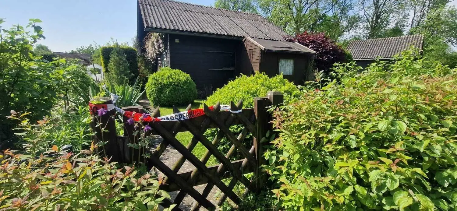 Einbruch in der Kleingartenanlage in Neu-Ulm: Nach einem Polizeieinsatz sind fünf Schrebergärten im Muthenhölzle mit Polizeiband als Tatort abgesperrt.