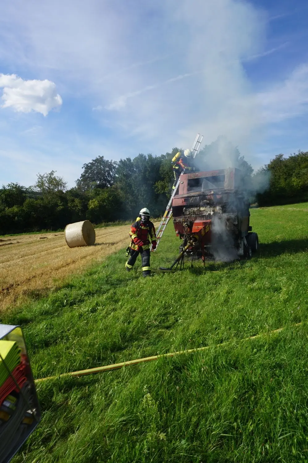 Die Feuerwehr löscht eine brennende Ballenpresse bei Laichingen-Feldstetten.