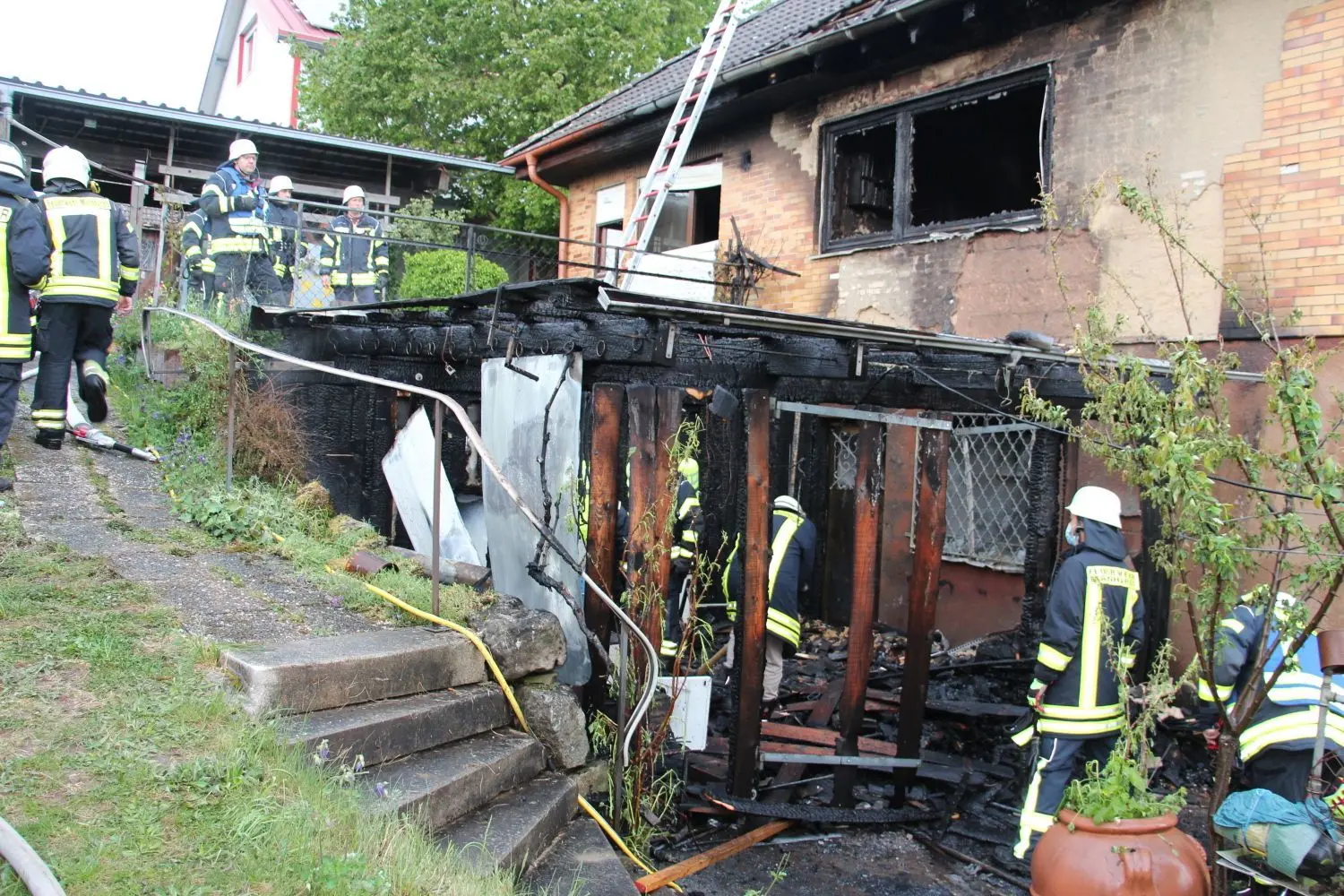 Mainhardter Feuerwehrleute untersuchen nach den erfolgreichen Löscharbeiten die Holzpergola des Einfamilienhauses in Ammertsweiler. Die Polizei vermutet, dass dort der Brand entstanden ist. ⇥