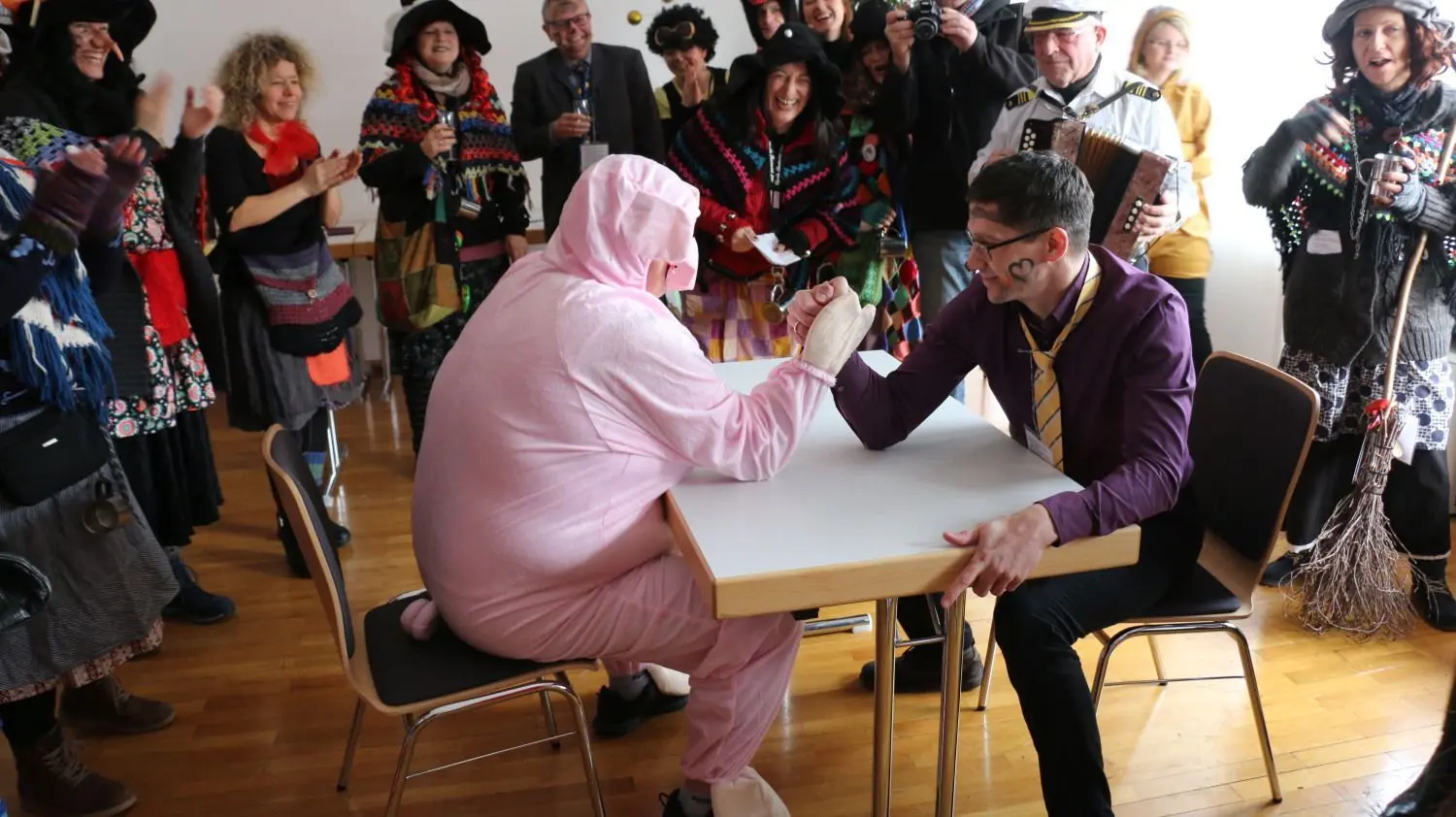 Stimpfachs Bürgermeister Martin Strobel ist beim Armdrücken gefordert. Das bessere Ende bei diesem launigen Showkampf hat aber Rathausmitarbeiterin Gabi Gehring.