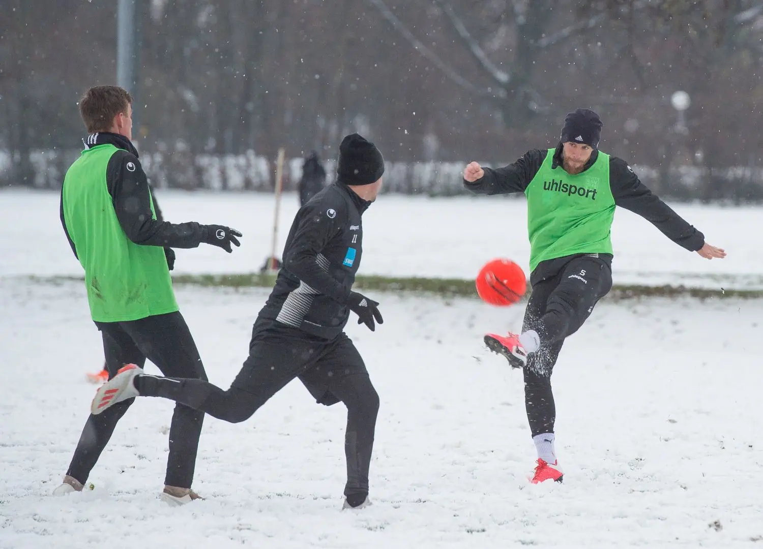 Ausstaffiert mit Mützen und Handschuhen: Die Spieler des SSV Ulm 1846 Fußball (am Ball Jo Reichert) mussten zum Auftakt des Trainings bei Minusgraden auf den Platz.⇥