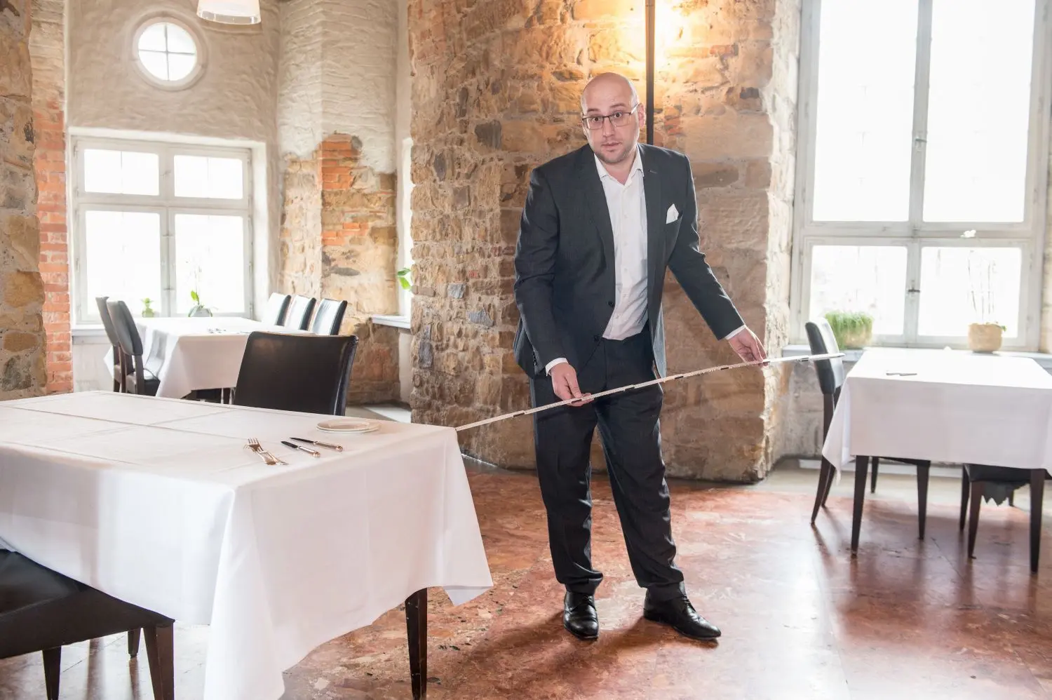 Gastronom Milos Vujicic misst im Restaurant auf Schloss Filseck den Abstand zwischen den Tischen.