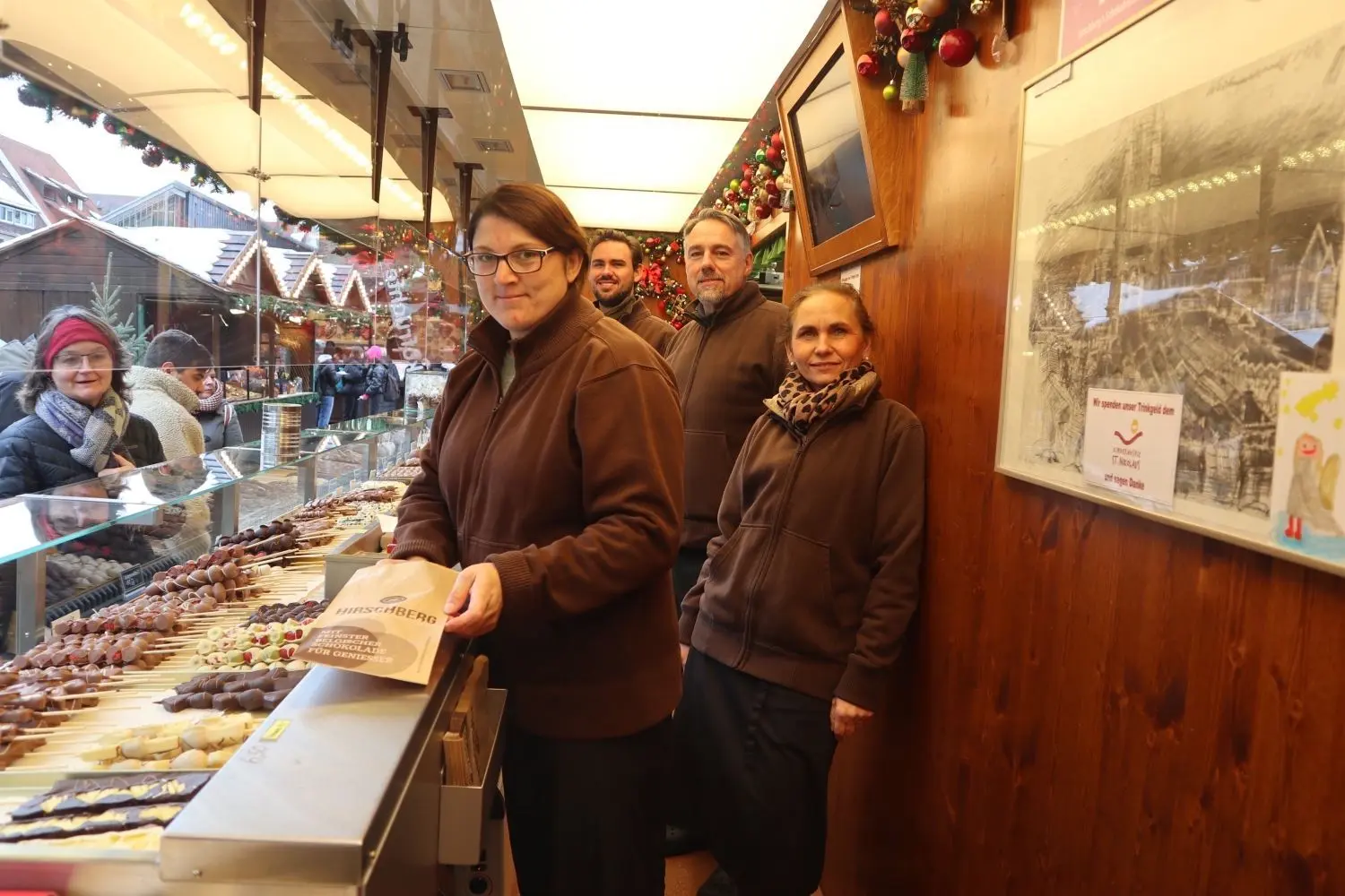 Aushilfe Sabine Klein (vorne) verpackt Schokofrüchte. Im Verkauf arbeiten auch Sohn Maximilian, Lorenz und Cornelia Hirschberg auf dem Ulmer Weihnachtsmarkt.
