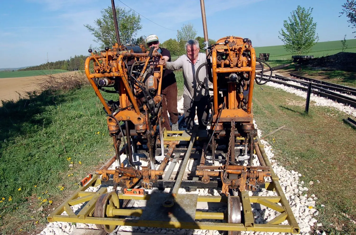  Bernd Scherer und Heiner Biro (rechts) auf dem Stopfer, mit dem der Schotter im Gleisbett verdichtet wird.⇥