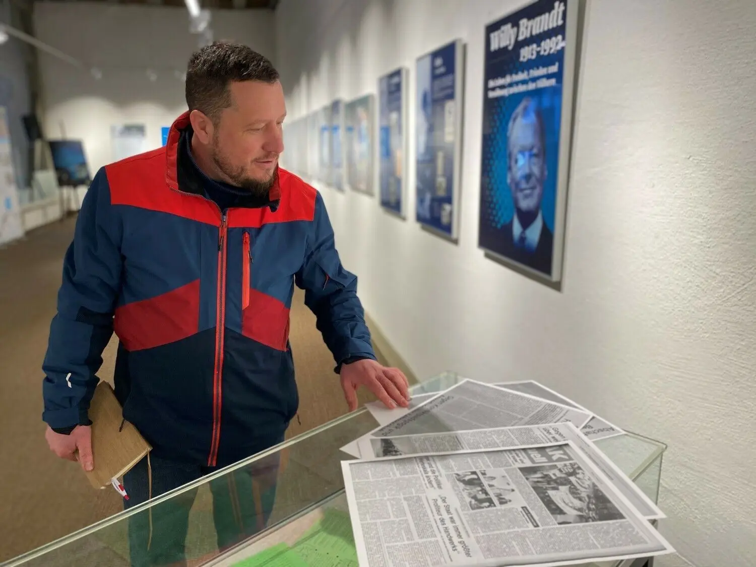Christopher Seng von der Zehntscheuer in Balingen blickt auf alte Zeitungsartikel über die Friedenswochen in Balingen. Dahinter: Exponate der Willy-Brandt-Ausstellung.