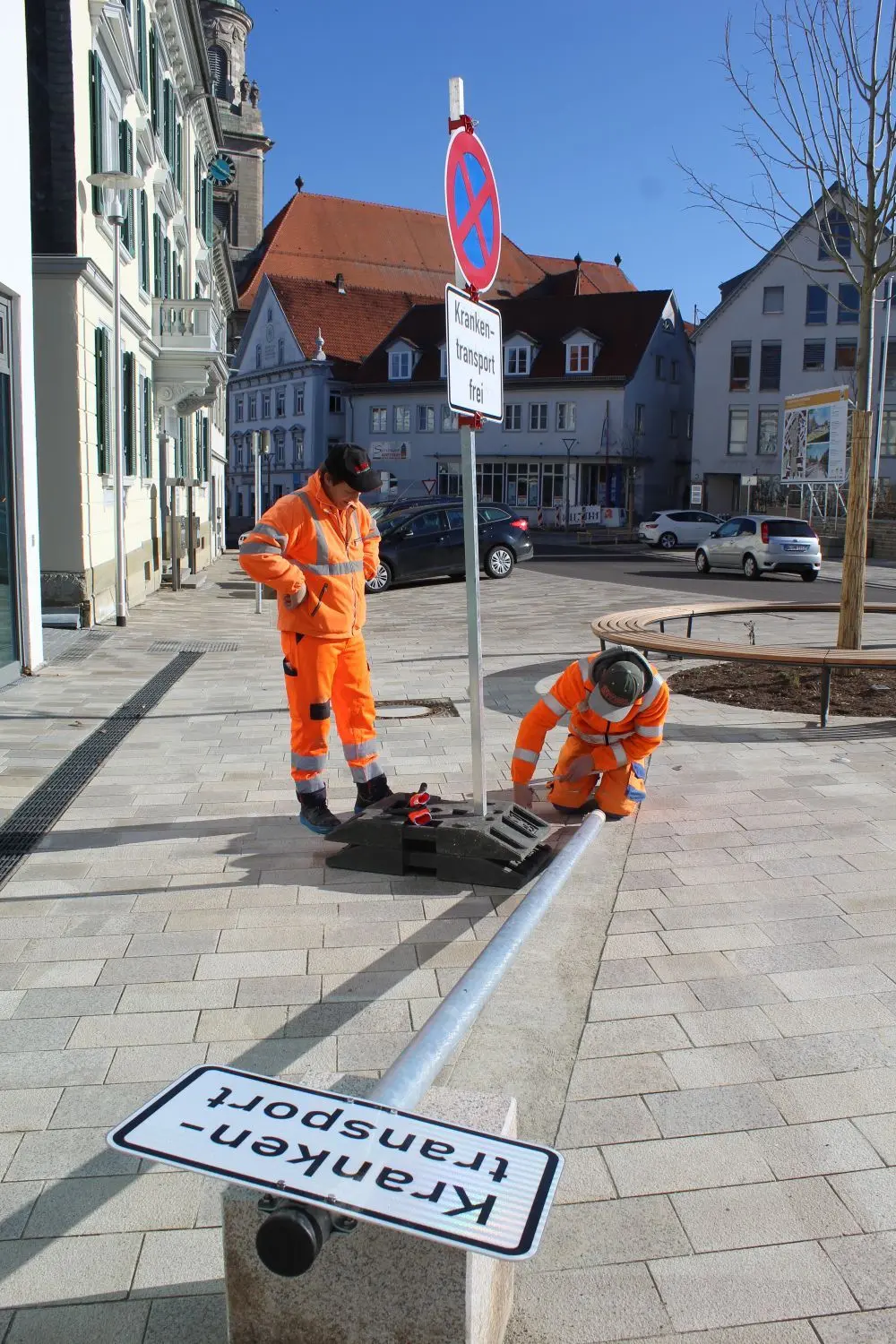 Aufgestellt, montiert, kontrolliert wurde am Montag auf dem Hechinger Obertorplatz, was das Zeug hält. Bild links zeigt Bauarbeiter der Firma Storz, die parkordnende  Schilder aufstellen. Auf dem mittleren Bild montieren Mitarbeiter der Stadtwerke die Sonderbeleuchtung für den Zebrastreifen ab, den es ab sofort nicht mehr gibt. Das rechte Bild zeigt die städtische Vollzugsbeamtin im Dauereinsatz an der Knöllchen-Front. Vor der Stadtapotheke in zweiter Reihe zu parken ist eben nicht erlaubt.⇥