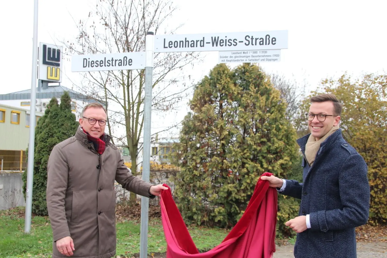 Marcus Herwarth, Vorsitzender der Geschäftsführung, und Bürgermeister Thomas Haas bei der Enthüllung des neuen Straßenschilds.