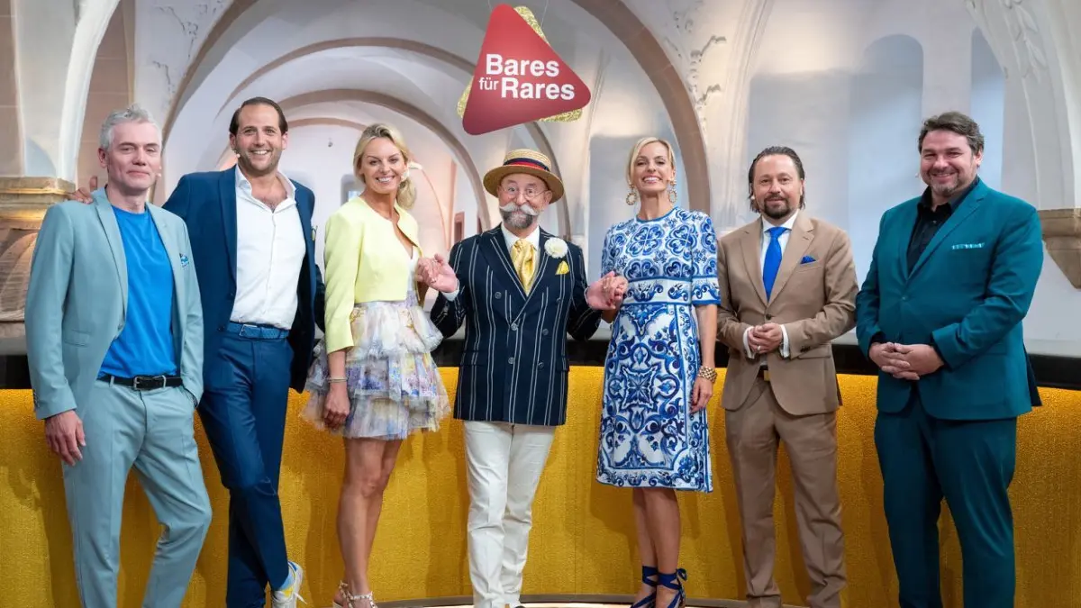 Die Händler bei „Bares für Rares“ bieten bei Interesse für die vorgelegten Artikel und treiben dadurch gegenseitig den Preis in die Höhe.
Von links: Christian Vechtel, Julian Schmitz-Avila, Susanne Steiger, Horst Lichter, Elisabeth „Lisa“ Nüdling, Wolfgang Pauritsch, Daniel Meyer.