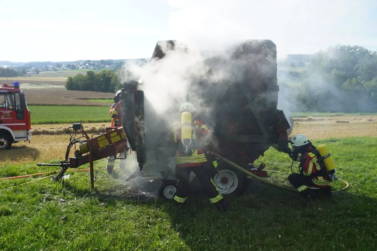 Die Feuerwehr löscht eine brennende Ballenpresse bei Laichingen-Feldstetten.