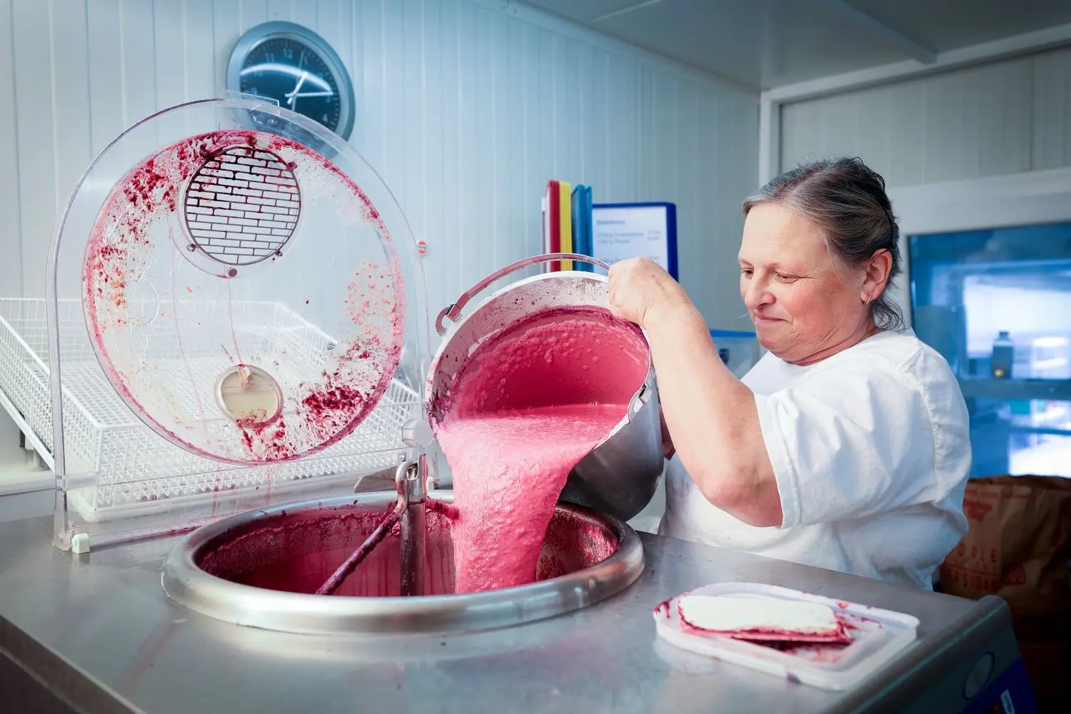 Die Märkleshof-Mitarbeiterin schüttet die Johannisbeer-Masse in die Eismaschine.
