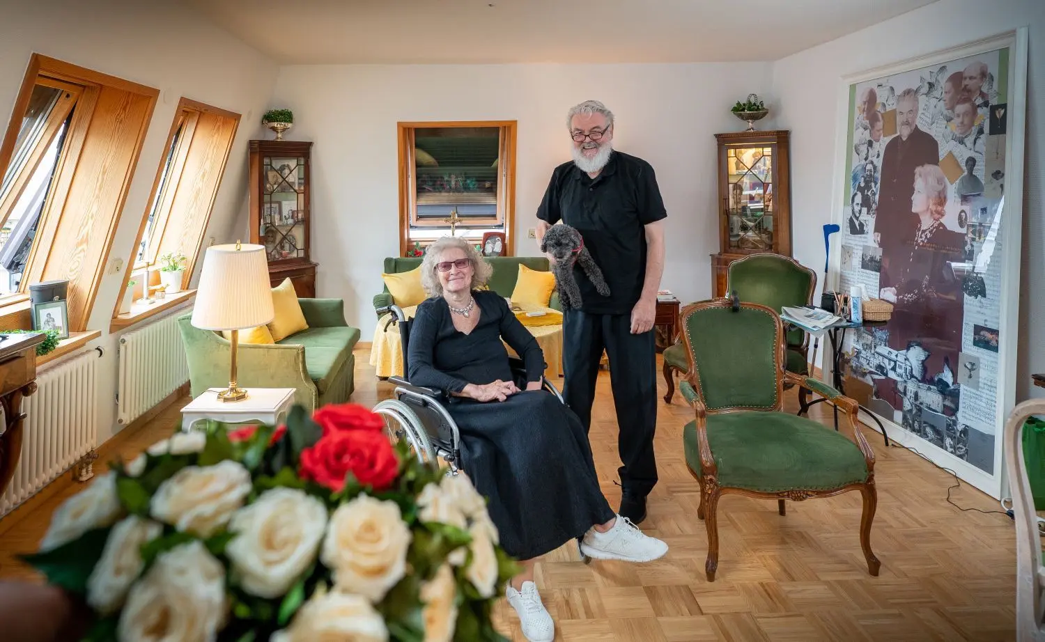  Ann-Charlotte und Wolf-Peter Schwarz mit Pudel Onyx III., rechts die Collage aus dem früheren „Schwedenzimmer“.⇥