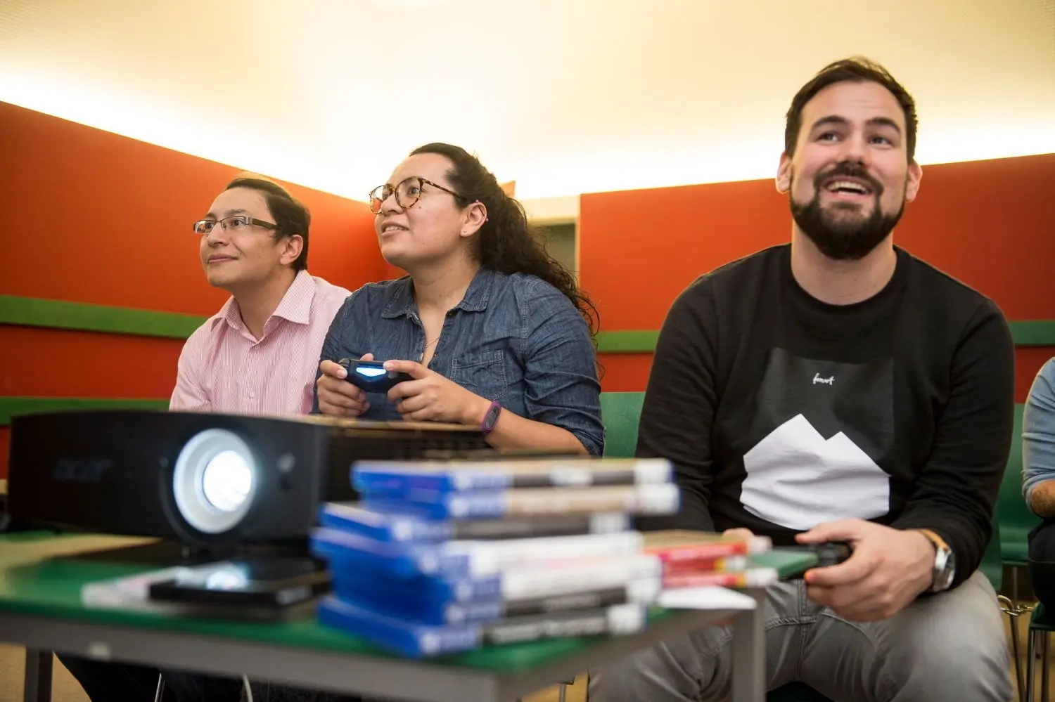 Eltern-Gaming in der Stadtbücherei: German Urrego und Natalia Pachon lassen sich von Krishan Cosmici (rechts) anleiten.