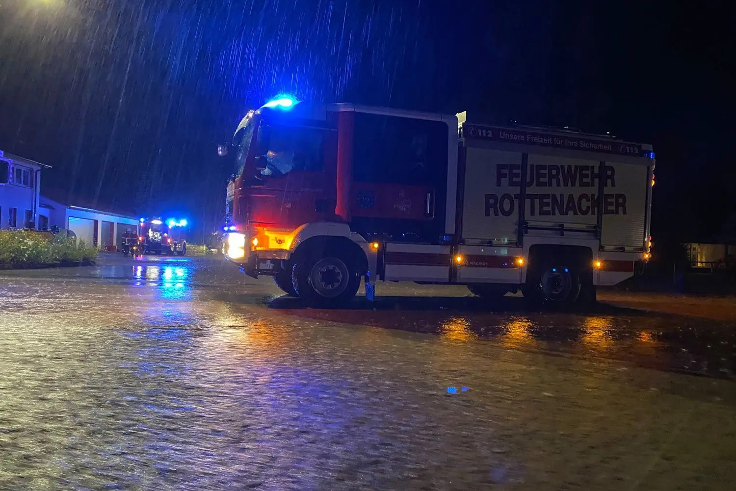 Im strömenden Regen kämpfen die Feuerwehrleute mit den Fluten.