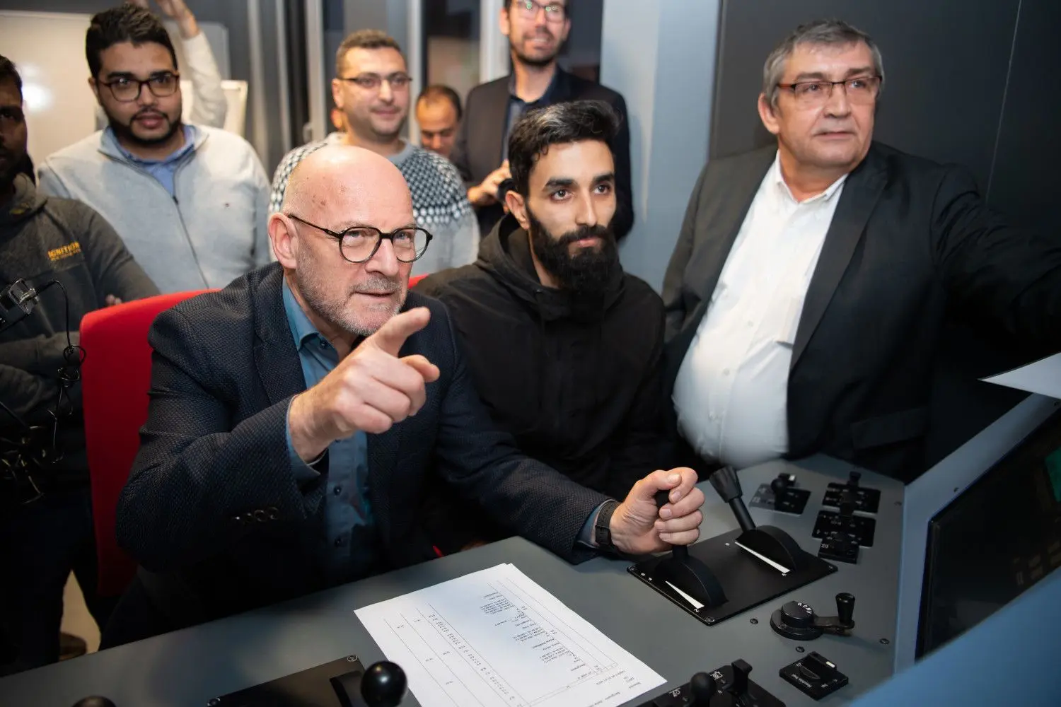Übungsstunde im Zugsimulator: Verkehrsminister Winfried Hermann (Grüne) mit Geflüchteten. ⇥