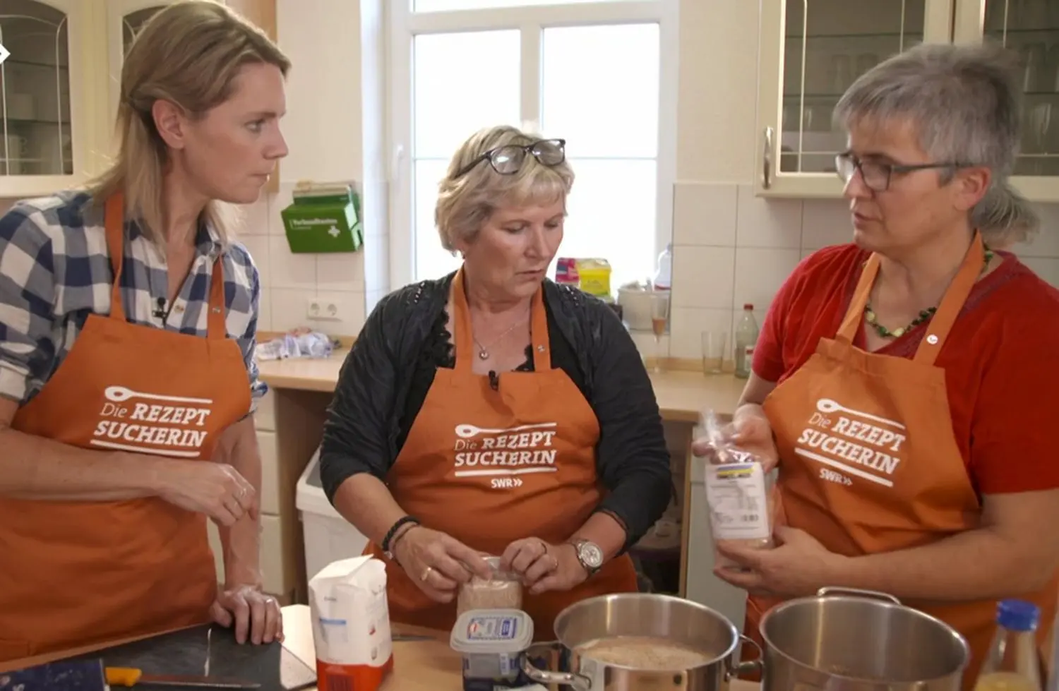 SWR-Reporterin Susanne Nett und die Landfrauen Marlies Freudemann und Annette Riehle am Herd im Bahnhofsgebäude (v.l.). Bevor’s ans Kochen ging gab’s eine Runde Sekt. Schnell war man per Du. ⇥