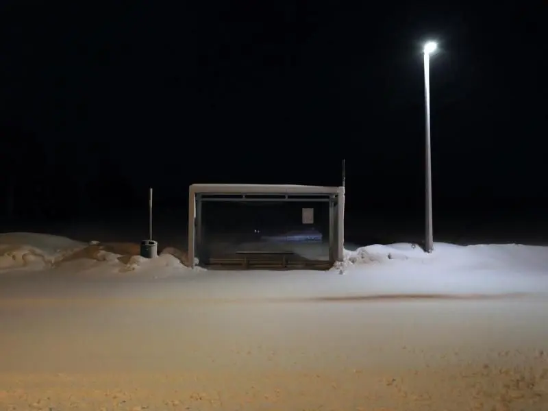 Eine Bushaltestelle an einer mit Neuschnee bedeckten Straße in Ruderatshofen. Foto: Karl-Josef Hildenbrand