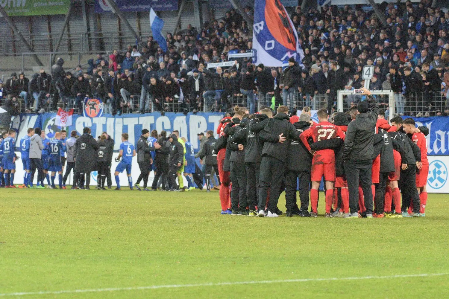 So nah liegen Freud und Leid nach einem Fußballspiel zusammen. Die Stuttgarter Kickers feiern im Hintergrund den Sieg und der SSV Reutlingen trauert den verpassten Chancen nach.