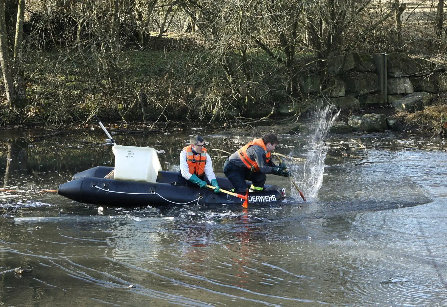 Einsatzkräfte der Freiwilligen Feuerwehr Hall schlagen mit Äxten die Eisschicht am Rückhaltebecken in Hessental ein. Später wird mit Pumpen Wasser umgewälzt, um den Sauerstoffgehalt im Wasser zu erhöhen. Die Aktion rettet viele Fische.