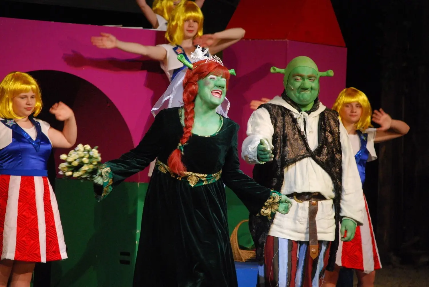 Prinzessin Fiona, hier in Oger-Gestalt, zusammen mit Shrek (oben). Shreks Gegenspieler ist Lord Farquaad (links unten, beim Verhör des Pfefferkuchenmanns). Zur Premiere des Kinderstücks war die Tribüne im Wasenwald gut gefüllt. ⇥