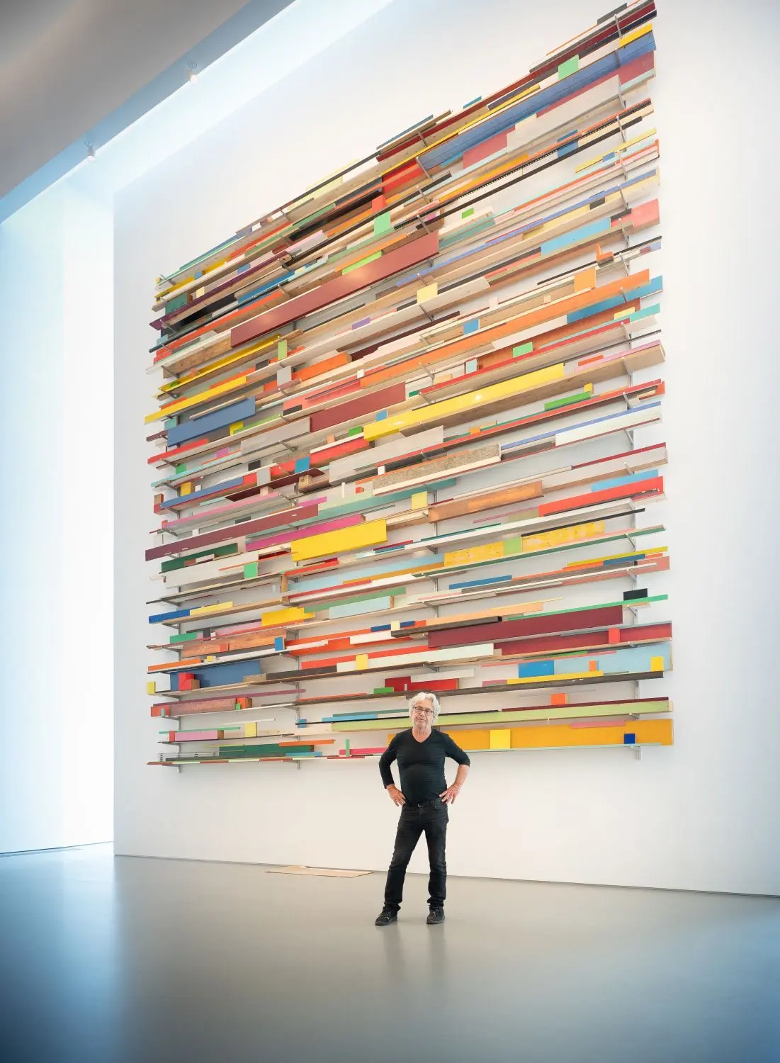 Der Schweizer Beat Zoderer vor dem Blickfang seiner Ausstellung in der Kunsthalle Weishaupt: Die Ulmer Version von „Horizontale Partitur, vertikal gelegt“ ist rund sieben Meter hoch.⇥