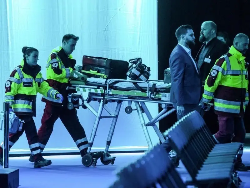 Mitarbeiter des Rettungsdienstes auf dem Weg in die Dortmunder Westfalenhalle, wo Wirtschaftsminister Peter Altmaier schwer gestürzt ist.