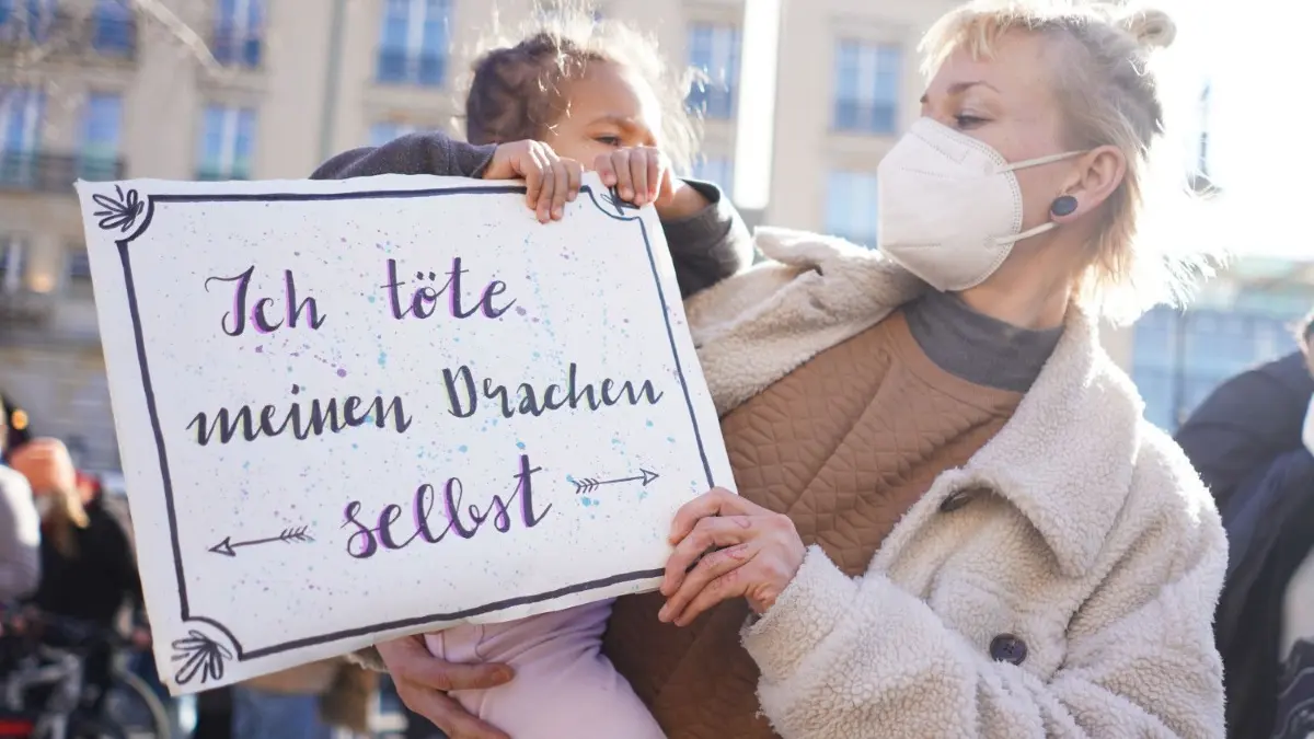 Ein Schild mit der Aufschrift "Ich töte meinen Drachen selbst" trägt eine Frau mit ihrer Tochter bei einer Demonstration zum Internationalen Frauentag vor dem Brandenburger Tor.
08.03.2021, Berlin: Ein Schild mit der Aufschrift "Ich töte meinen Drachen selbst" trägt eine Frau mit ihrer Tochter bei einer Demonstration zum Internationalen Frauentag vor dem Brandenburger Tor. Seit genau 100 Jahren wird an jedem 8. März weltweit für Frauenrechte, für Gleichberechtigung und Emanzipation demonstriert. Foto: Jörg Carstensen/dpa +++ dpa-Bildfunk +++