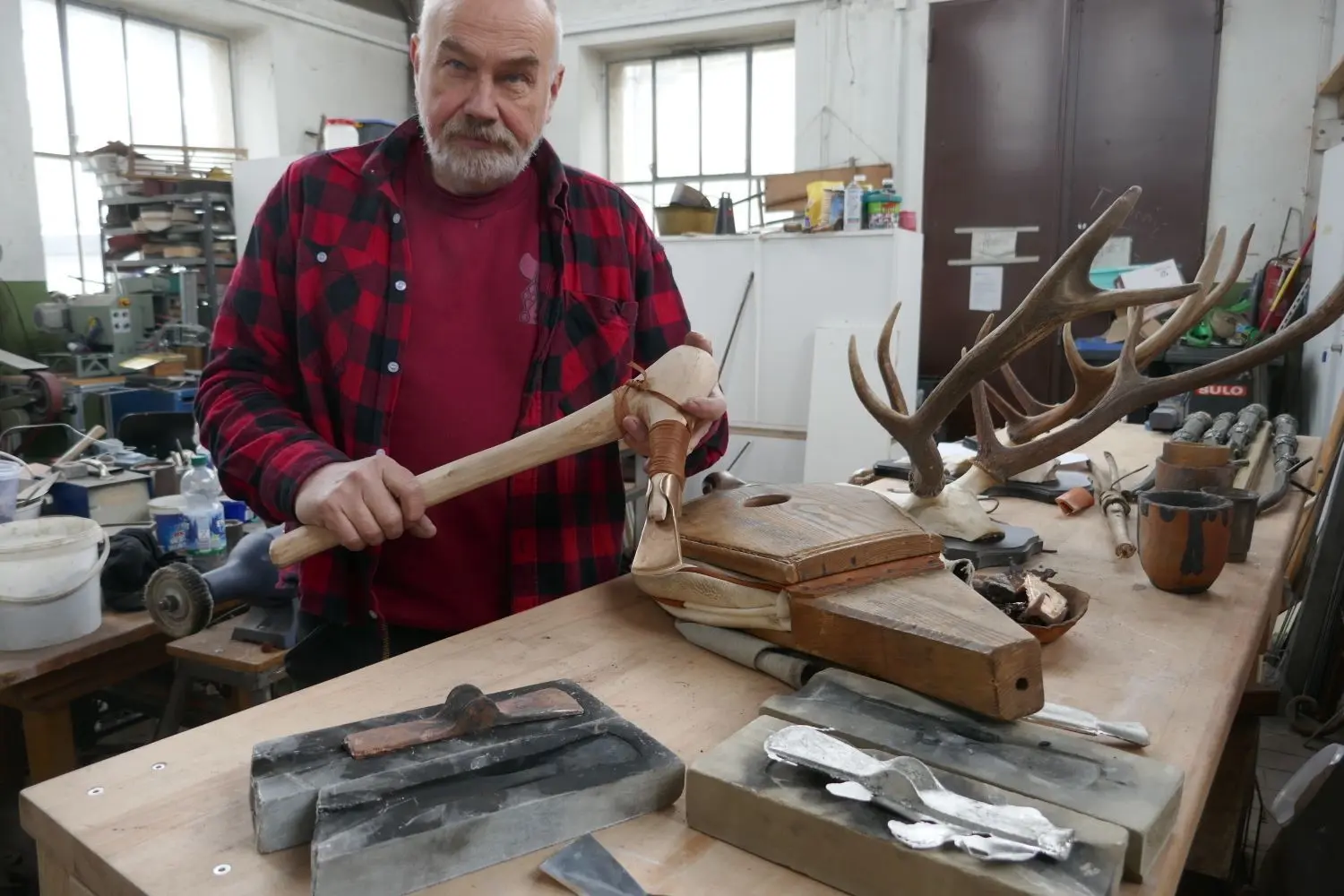 Frank Trommer hält das fertige Bronzebeil in der Hand.⇥