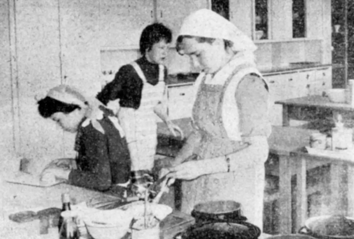 Ab 1945 steht auch Kochen auf dem Lehrplan: Das Foto zeigt, wie Schülerinnen 1961 bei einer Prüfung die Speisen anrichten.