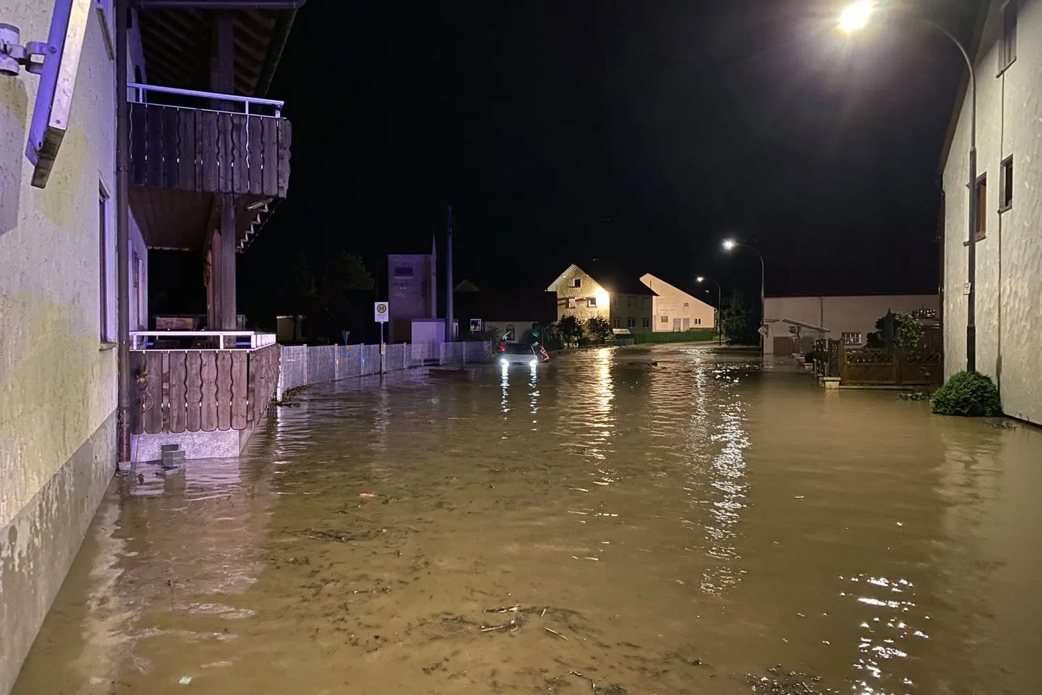Land unter in Mühlhausen. Um zum feststeckenden Pkw zu gelangen, müssen die Feuerwehrleute durchs hüfttiefe Wasser waten.