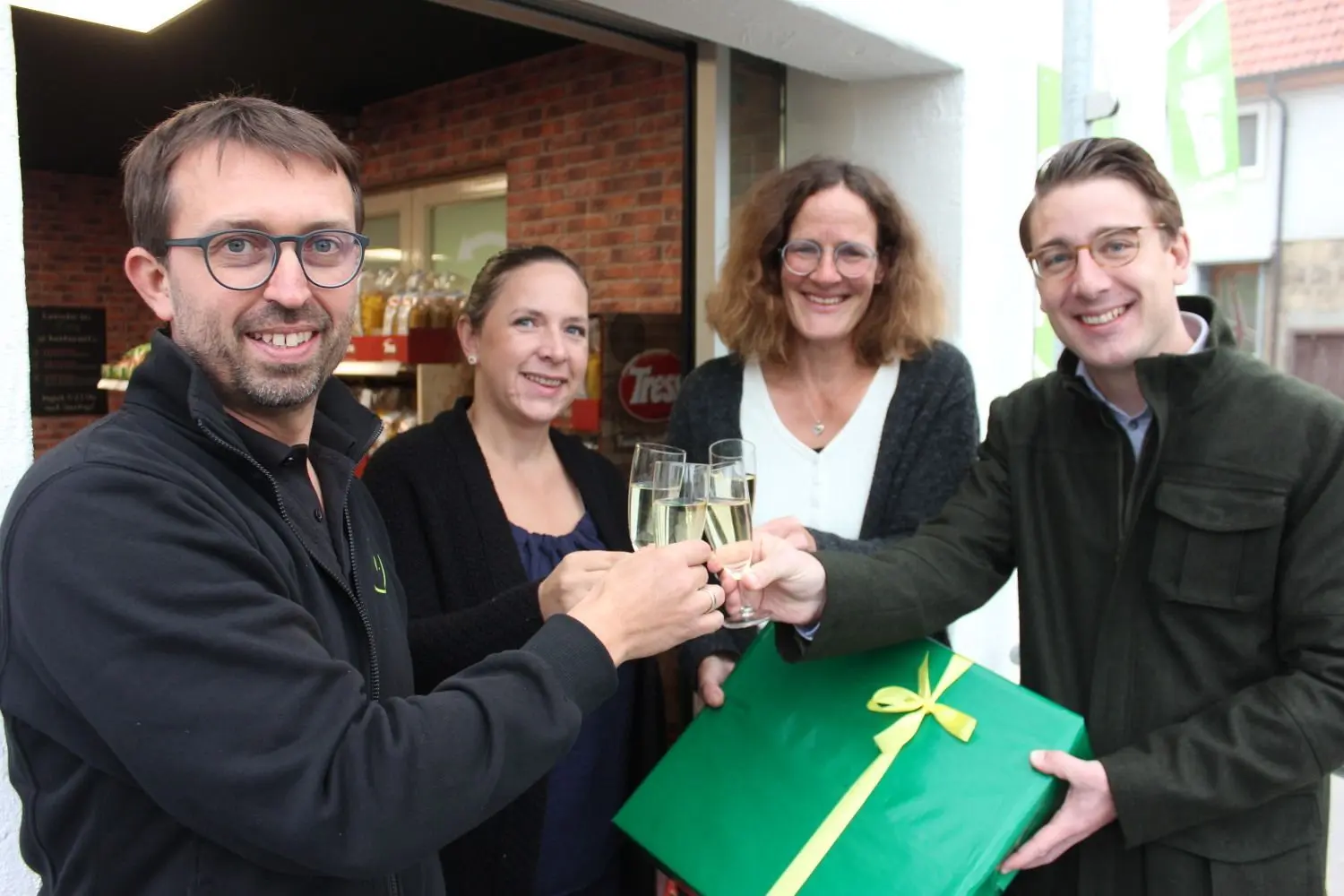 Betreiber Christian Maresch, eine Mitarbeiterin, Ortsvorsteherin Sandra Schäfer und Bürgermeister Davide Licht stießen auf die Zukunft des Stettener Dorfladens an. In der Geschenkschachtel? Eine „Burladinger Uhr“ für Christian Maresch. ⇥
