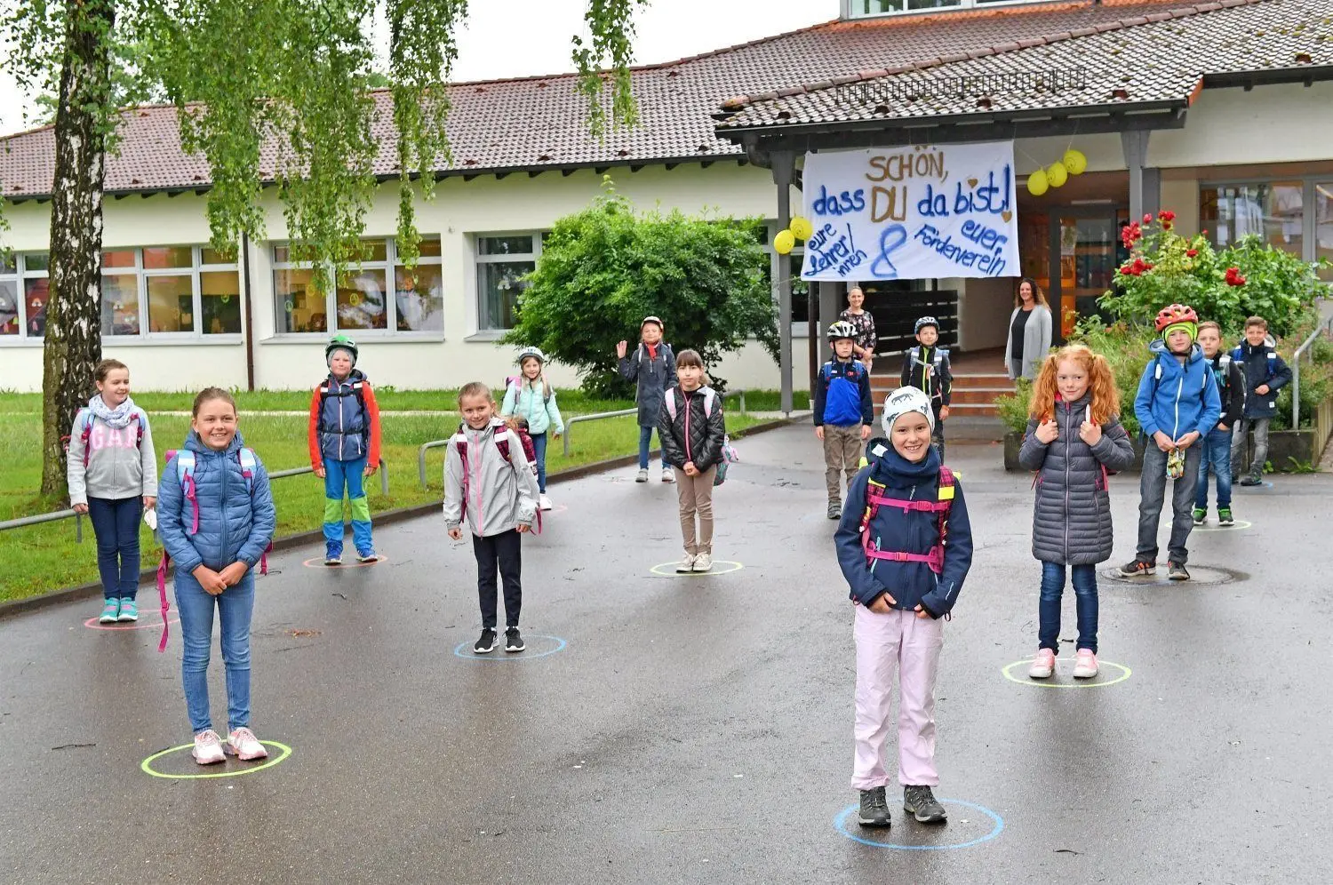 Bevor sie das Schulgebäude betraten, mussten sich die Grundschüler in Öpfingen in einen aufgemalten Kreis auf dem Schulhof stellen. Über dem Eingang das Transparent, mit dem sie begrüßt wurden.⇥