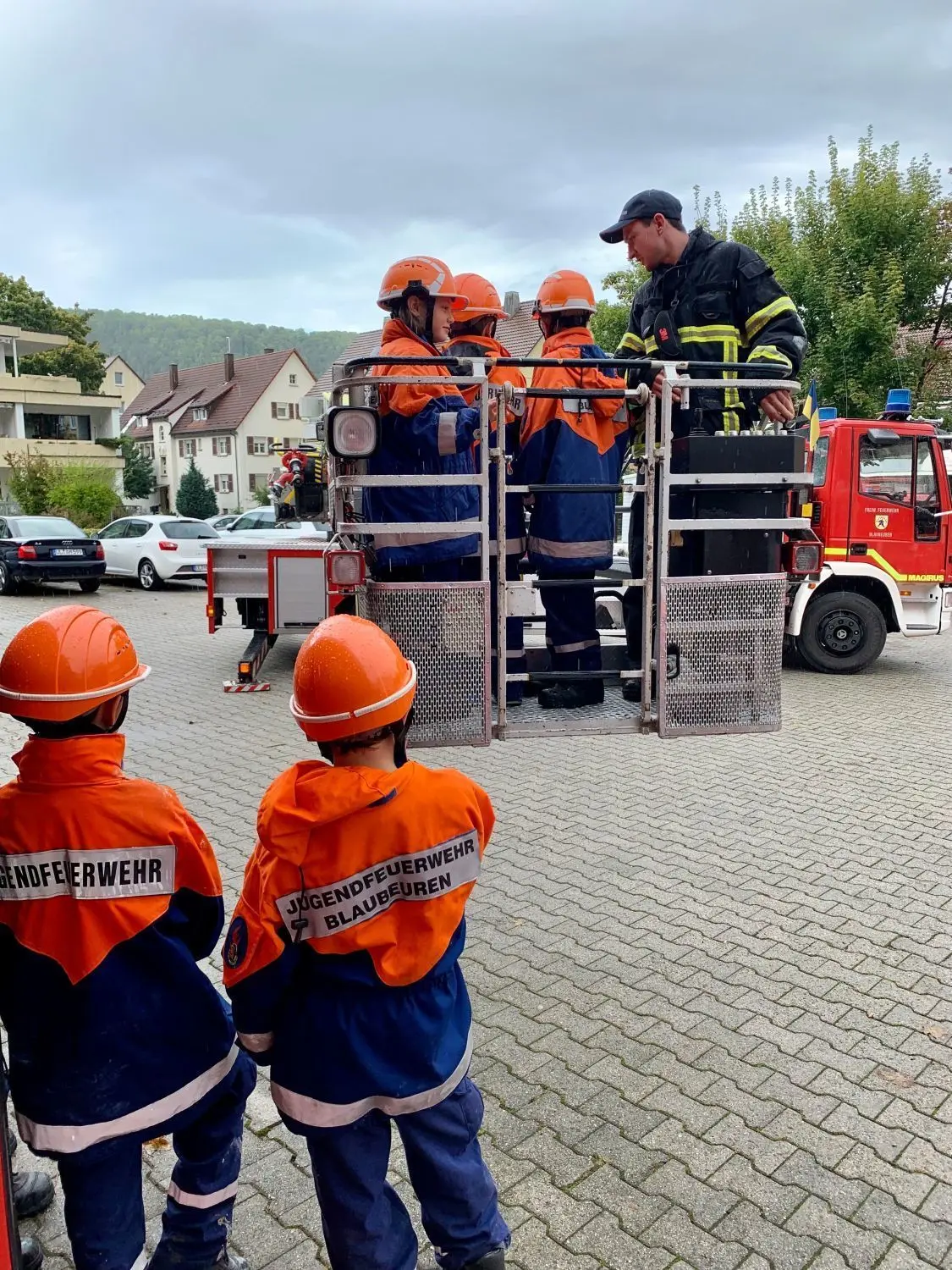 Junge Feuerwehrleute auf der Drehleiter.