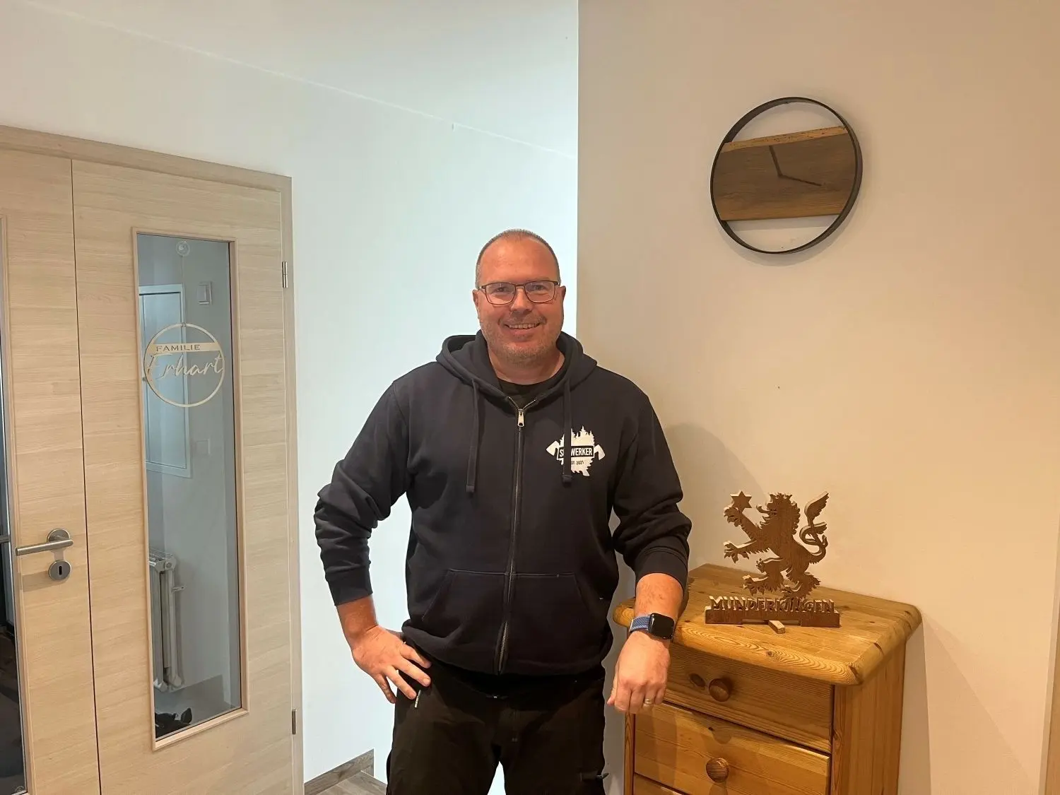 Armin Erhart mit dem Aufsteller des Munderkinger Löwen und einem einfacheren Türschild. Der Löwe entstand aus dem Holz einer alten Eingangstüre.⇥